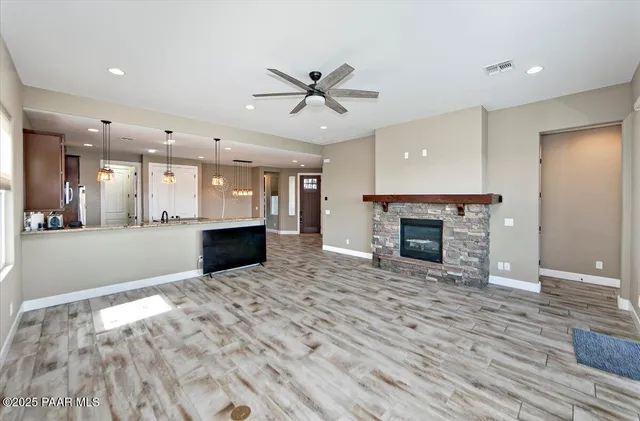 a view of a big room with wooden floor and a kitchen