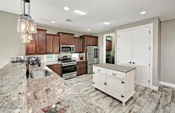 a kitchen with stainless steel appliances granite countertop a stove refrigerator and cabinets