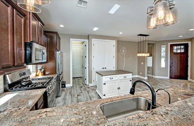 a kitchen with a sink stove top oven and refrigerator