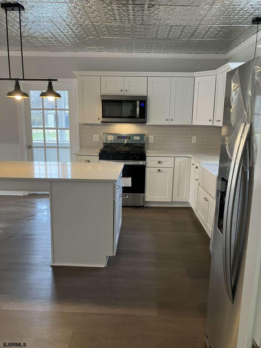 23 Leeds Point Road Galloway Township, NJ 08205 - Photo 6 of 23 a kitchen with stainless steel appliances granite countertop a refrigerator a stove and a sink with wooden floor