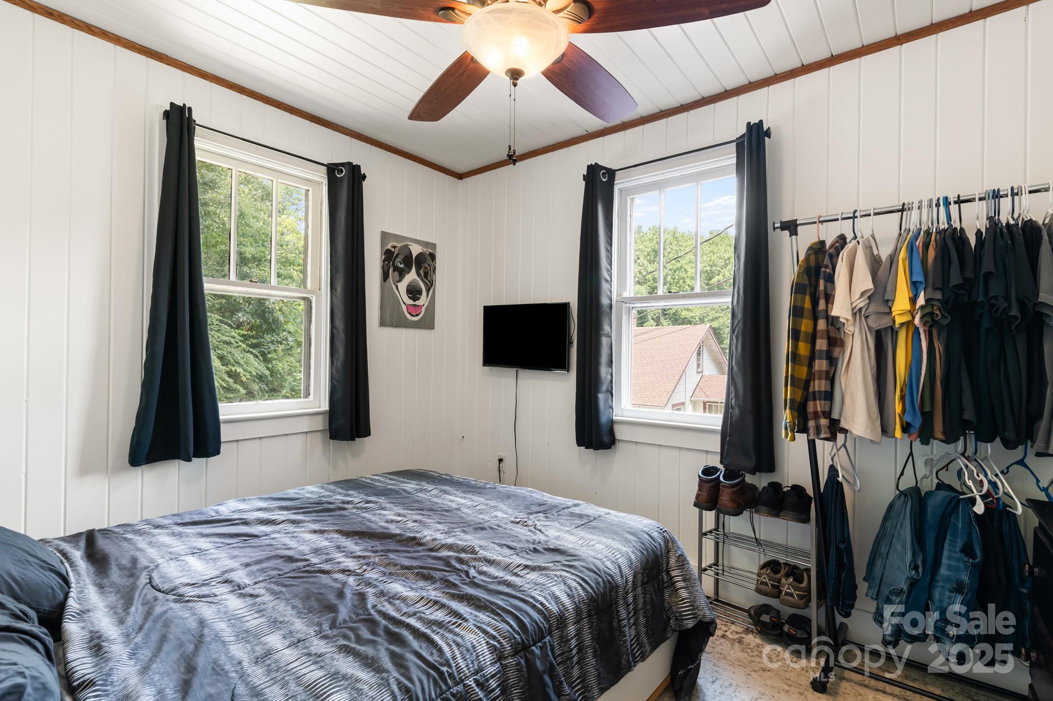 245 Hookers Gap Road Candler, NC 28715 - Photo 13 of 44 a bedroom with a bed a flat screen tv and a large window with the garden view