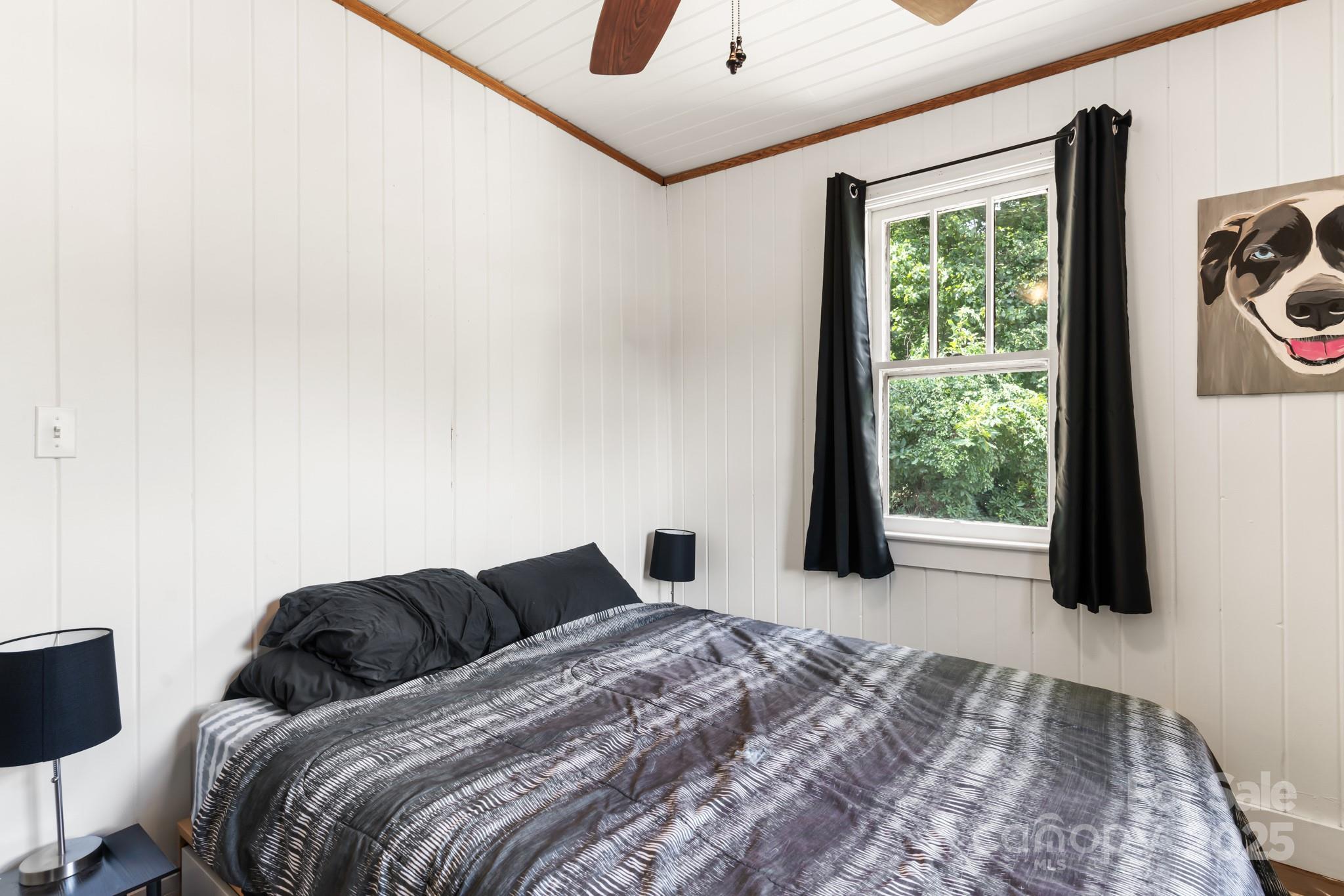 245 Hookers Gap Road Candler, NC 28715 - Photo 14 of 44 a bedroom with a bed and a large window
