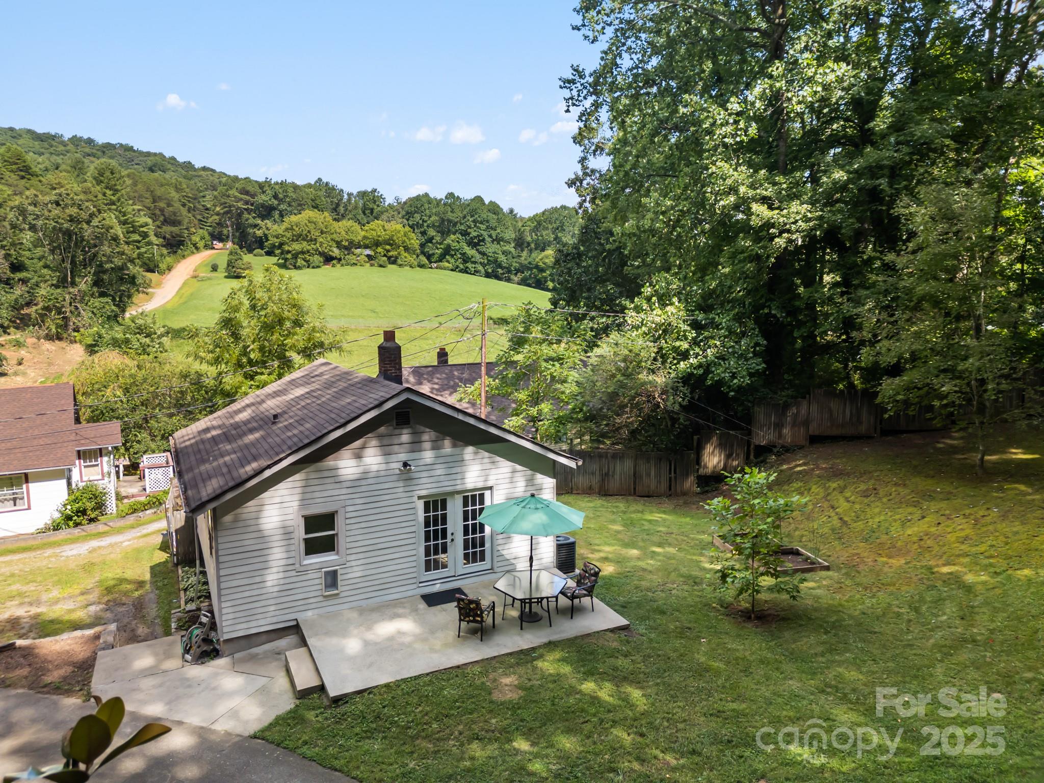245 Hookers Gap Road Candler, NC 28715 - Photo 2 of 44 a backyard of a house with table and chairs