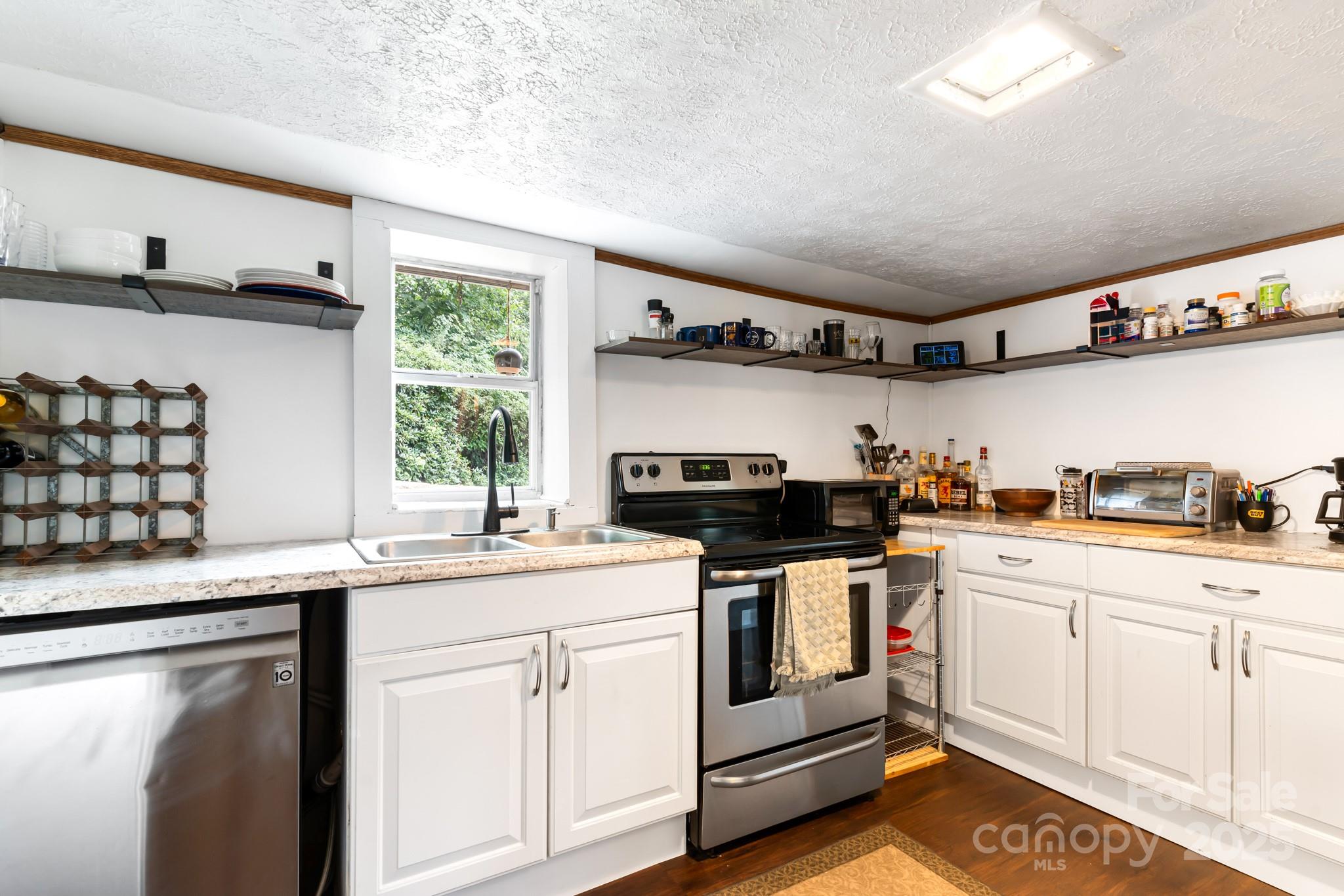 245 Hookers Gap Road Candler, NC 28715 - Photo 24 of 44 a kitchen with granite countertop a sink and cabinets