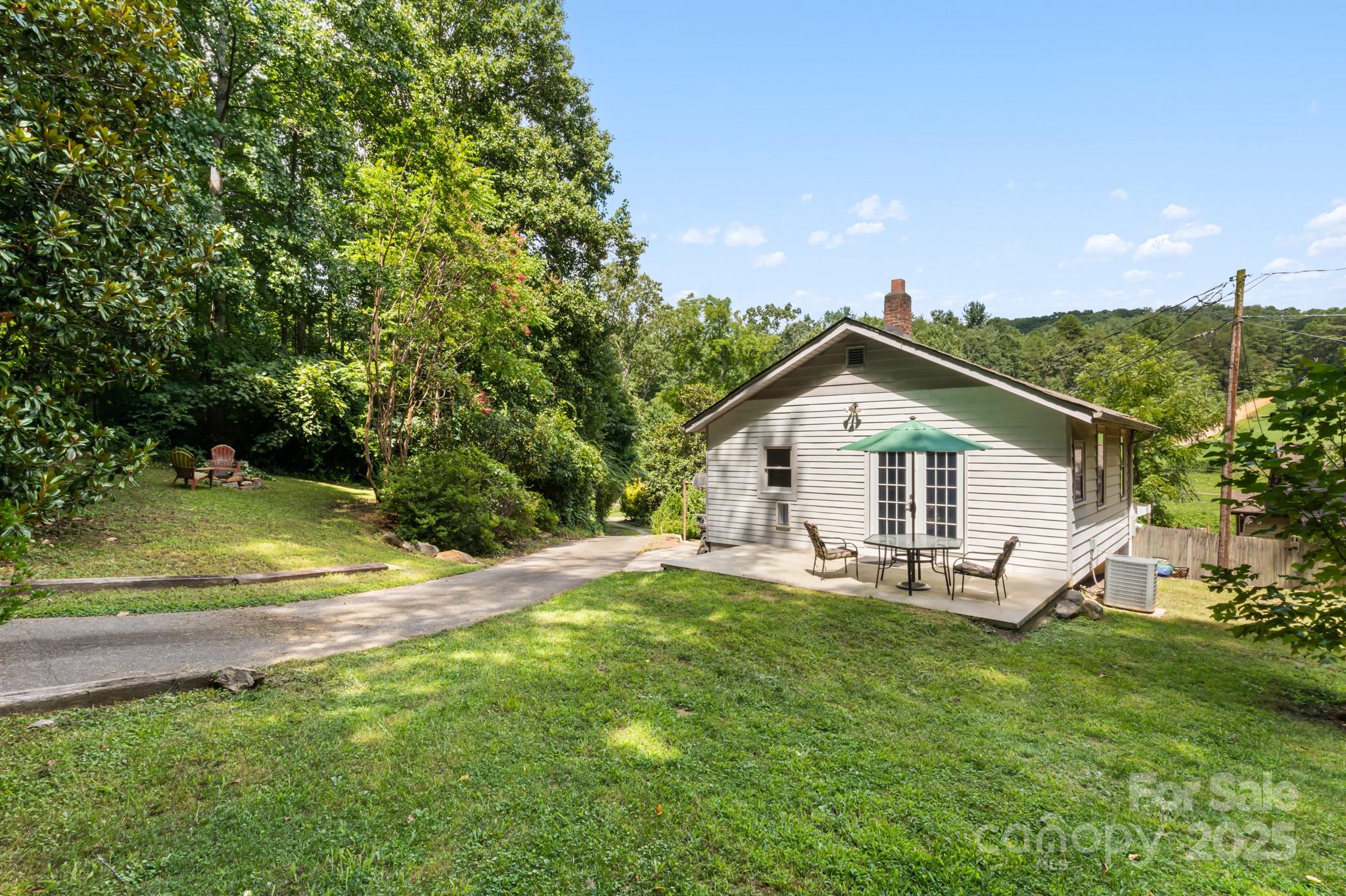 245 Hookers Gap Road Candler, NC 28715 - Photo 7 of 44 a view of a house with a yard and large trees