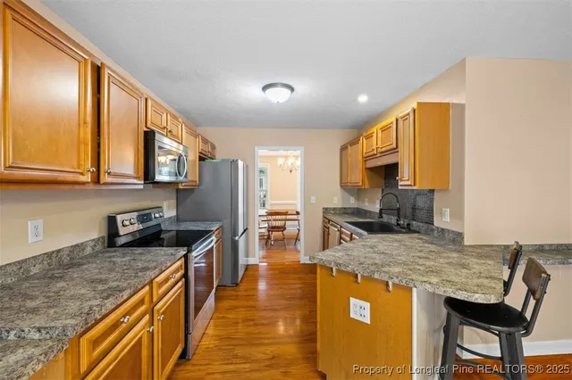 a kitchen with stainless steel appliances granite countertop a sink stove and refrigerator
