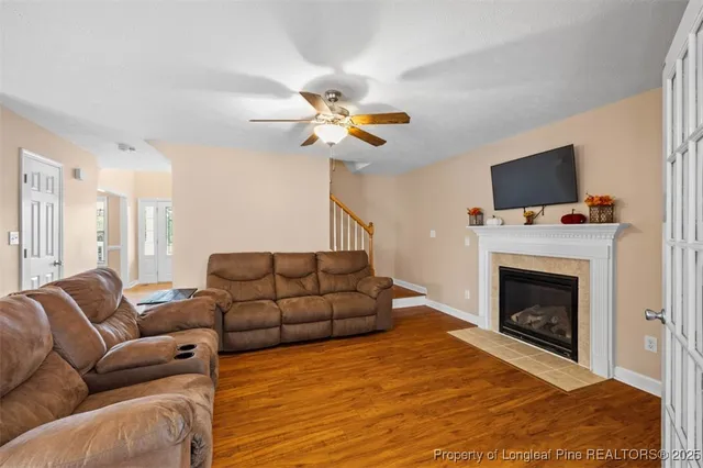 a living room with furniture a fireplace and a flat screen tv
