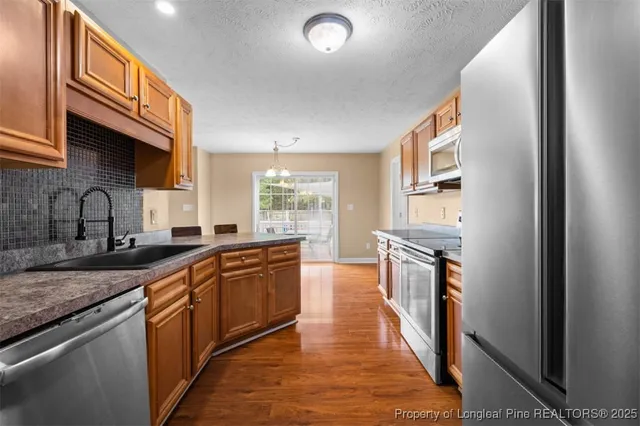 a large kitchen with stainless steel appliances granite countertop a stove and a sink