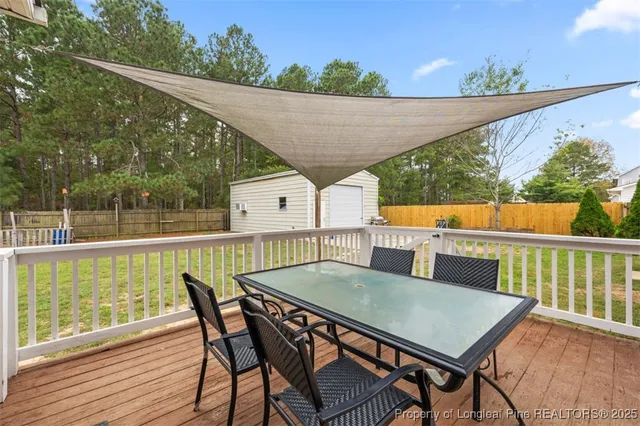 a balcony with wooden floor table and chairs