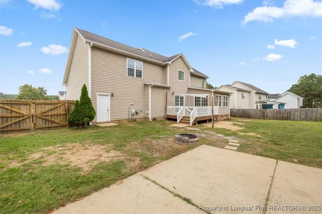 a view of a white house next to a yard and road