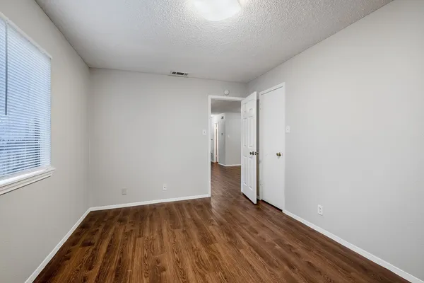 a view of a room with wooden floor and a window