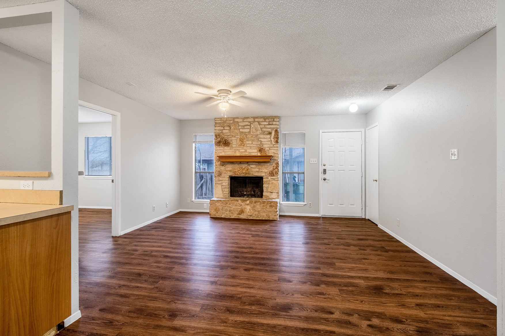 604 Misty Morning Way, Unit B Round Rock, TX 78664 - Photo 2 of 23 an empty room with wooden floor fireplace and windows