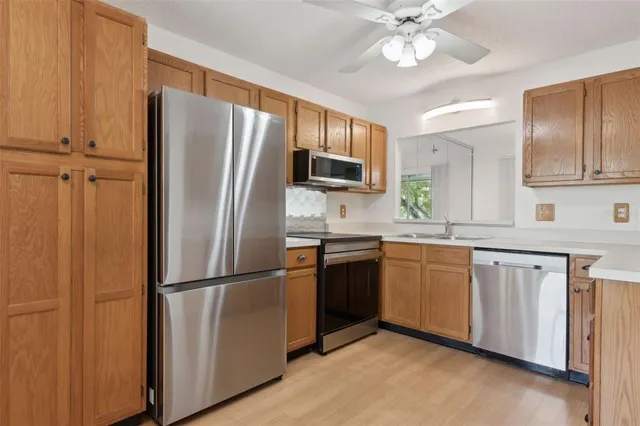 a kitchen with stainless steel appliances and refrigerator