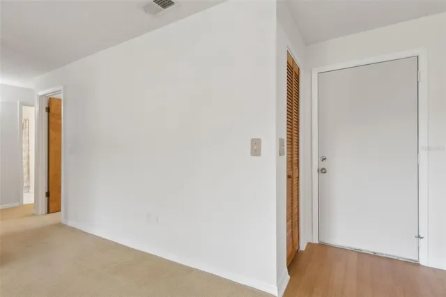 an empty room with windows and ceiling fan