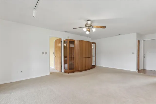 a view of a hallway with chandelier and refrigerator