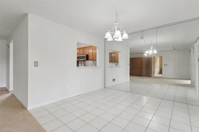 an empty room with chandelier and windows