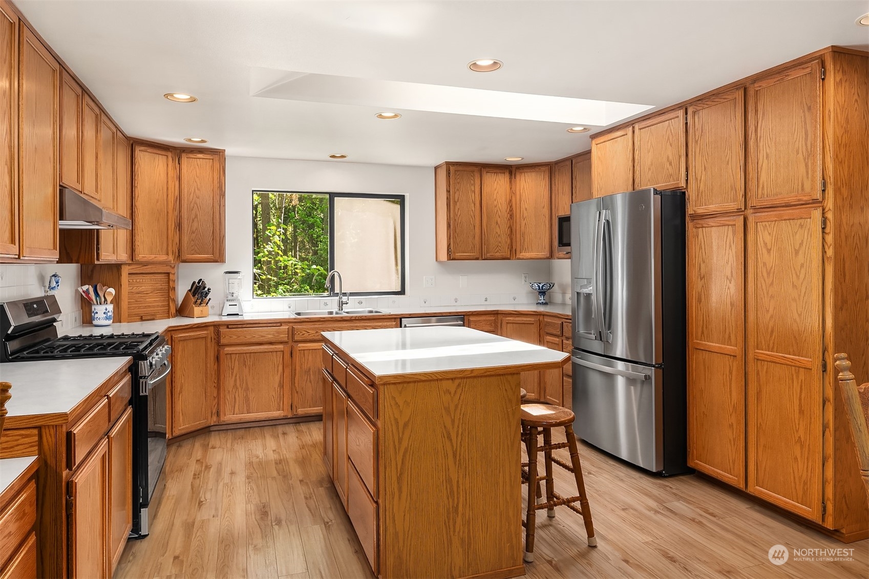 23017 38th Avenue Southeast Bothell, WA 98021 - Photo 11 of 38 a kitchen with stainless steel appliances granite countertop a refrigerator a sink dishwasher a stove and white countertops with wooden floor