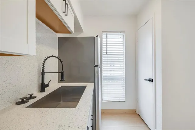a kitchen with white cabinets stainless steel appliances and sink