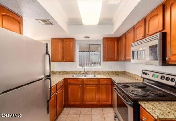 17211 North 35th Avenue, Unit C112 Phoenix, AZ 85053 - Photo 5 of 17 a kitchen with stainless steel appliances granite countertop a stove a sink and a microwave