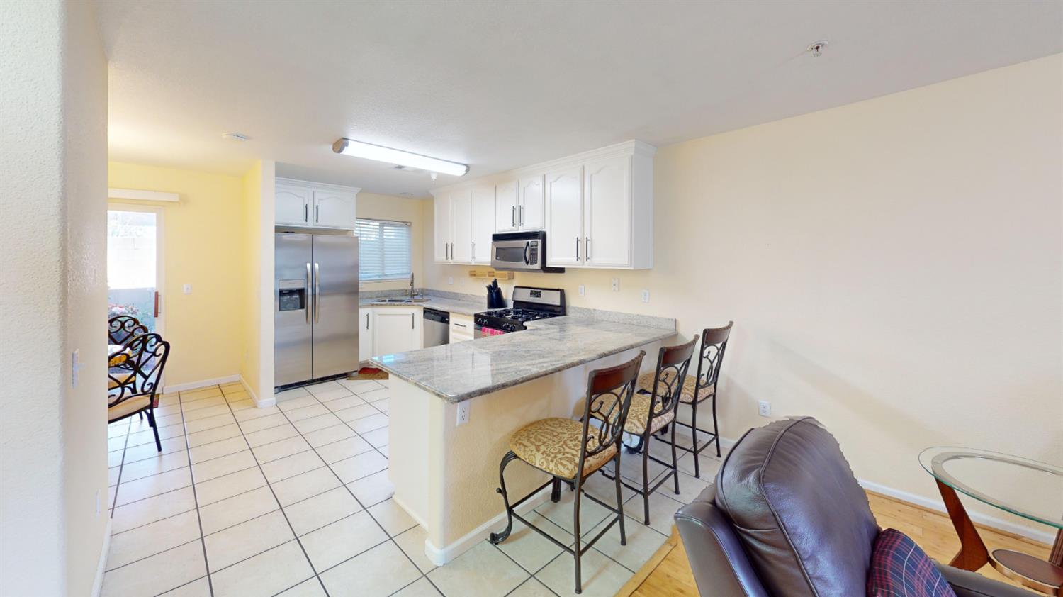 4057 Dale Road, Unit B Modesto, CA 95356 - Photo 6 of 39 a kitchen with stainless steel appliances kitchen island granite countertop a stove a refrigerator a sink a dining table and chairs with wooden floor