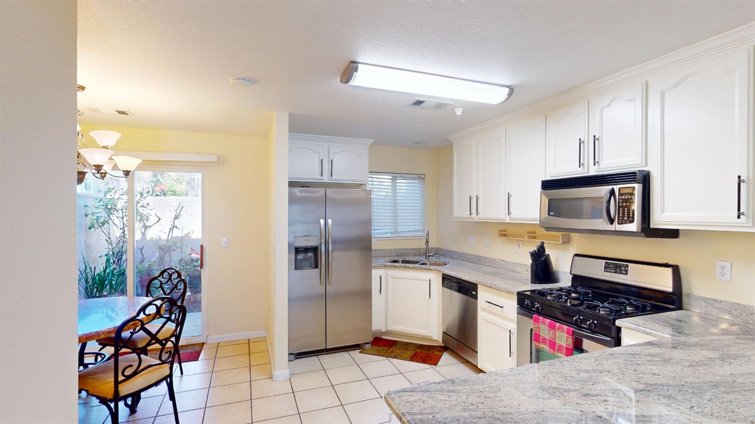 4057 Dale Road, Unit B Modesto, CA 95356 - Photo 9 of 39 a kitchen with stainless steel appliances kitchen island granite countertop a refrigerator and a stove top oven
