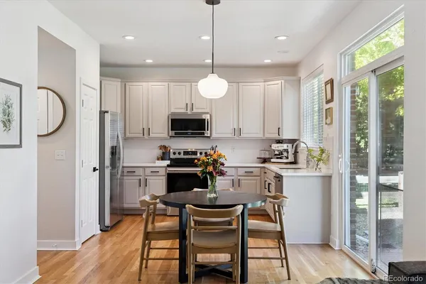 a kitchen with white cabinets and stainless steel appliances