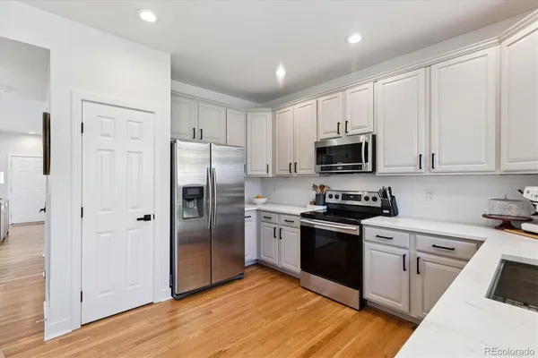 a kitchen with cabinets stainless steel appliances and wooden floor