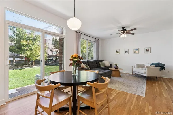 a dining room with furniture a chandelier and wooden floor