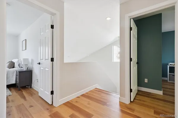 a view of a hallway with bathroom and wooden floor