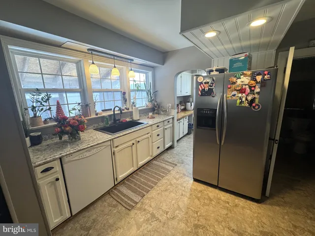 a kitchen with stainless steel appliances granite countertop a refrigerator and a sink