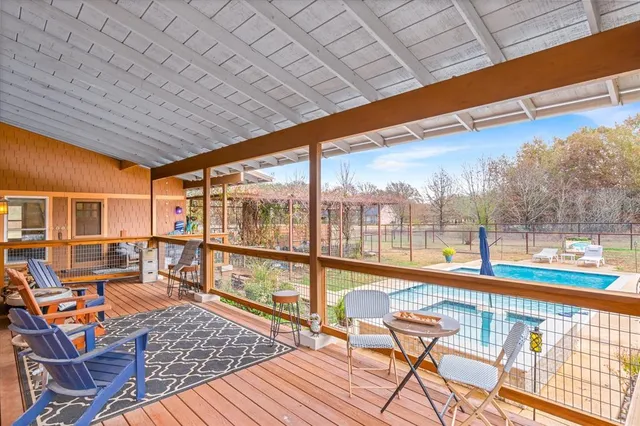 a balcony with wooden floor and outdoor seating