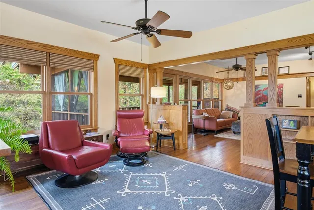 a living room with furniture a rug and a floor to ceiling window