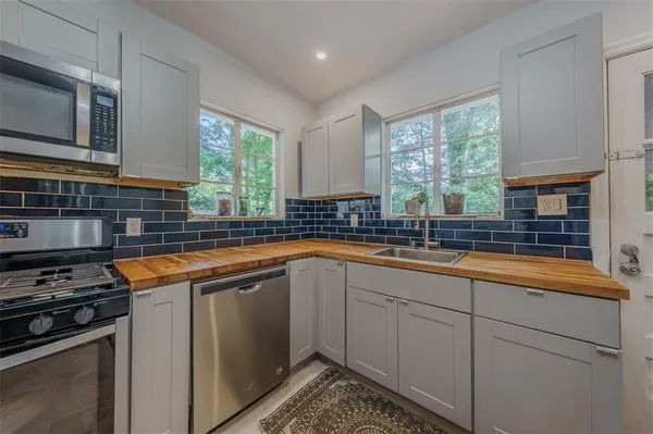 a kitchen with stainless steel appliances granite countertop a sink stove and microwave