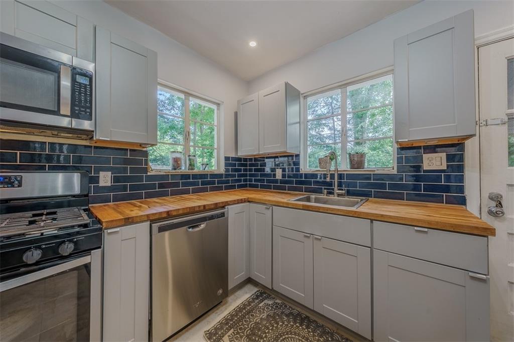 1920 West Forrest Avenue Atlanta, GA 30344 - Photo 11 of 28 a kitchen with stainless steel appliances granite countertop a sink stove and microwave