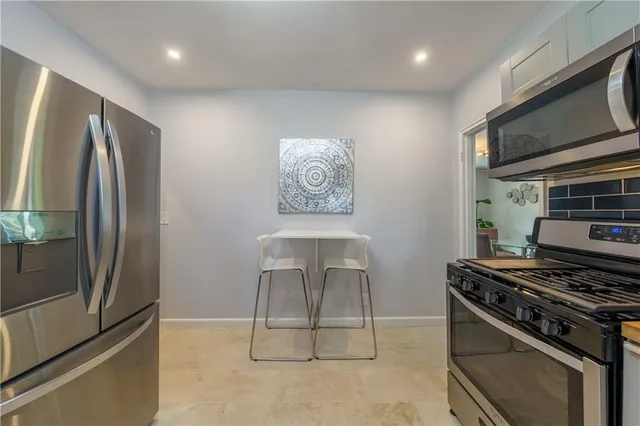 a kitchen with stainless steel appliances granite countertop a stove a refrigerator and a microwave