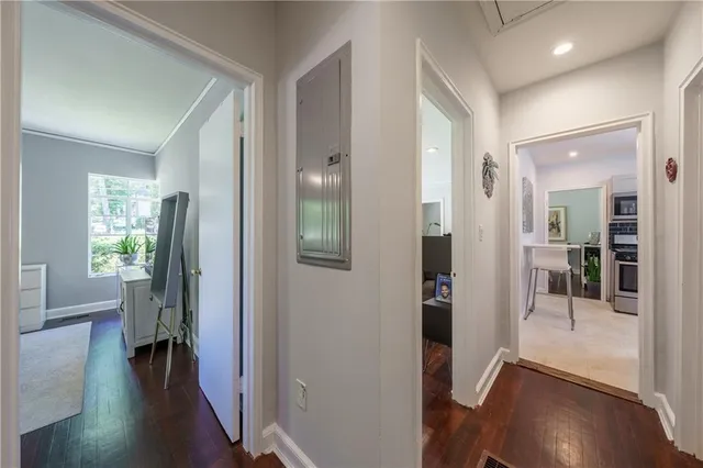 a view of a hallway with wooden floor and a living room