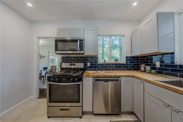 a kitchen with stainless steel appliances a stove a sink and a microwave
