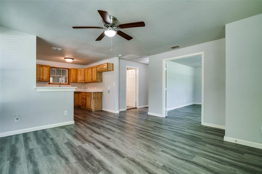 606 West High Street Terrell, TX 75160 - Photo 7 of 28 a view of a kitchen with wooden floor and a ceiling fan