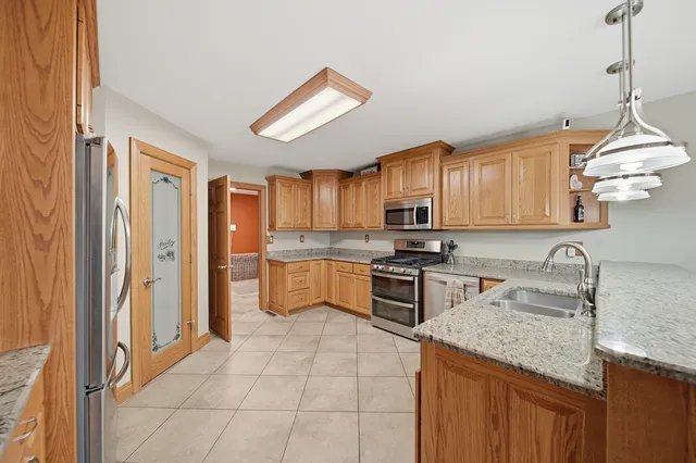 a kitchen with stainless steel appliances granite countertop a stove sink and cabinets