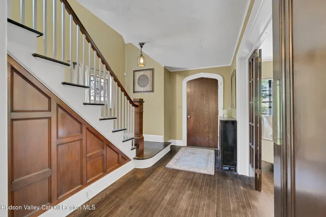 a view of a hallway with wooden floor and staircase