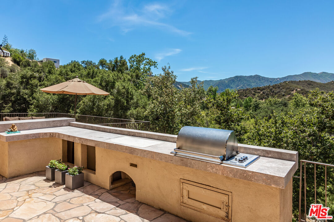 1045 Cold Canyon Road Calabasas, CA 91302 - Photo 21 of 51 a view of a patio with furniture and a backyard