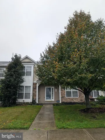 a front view of a house with a garden and trees