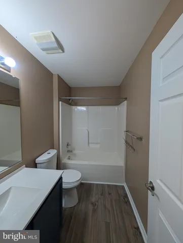 a bathroom with a sink a toilet a mirror and shower