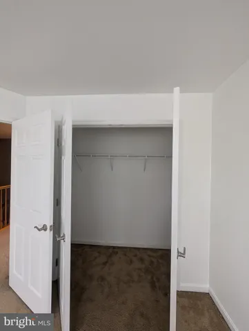 an empty room with a ceiling fan and window