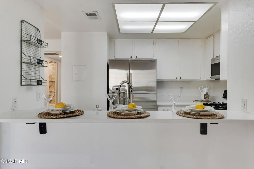 1912 Heywood Street, Unit D Simi Valley, CA 93065 - Photo 4 of 40 a kitchen with a refrigerator a stove and wooden floor
