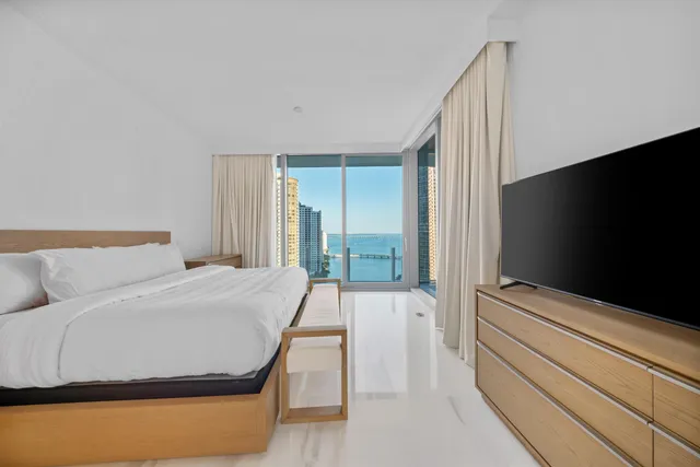 a large white bathroom with a large mirror vanity and shower