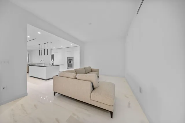 a large white kitchen with a large counter top and stainless steel appliances
