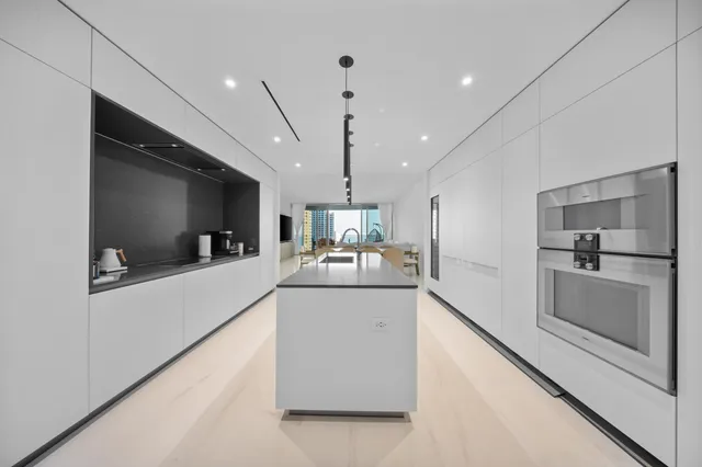 a large white kitchen with a large counter top appliances and cabinets