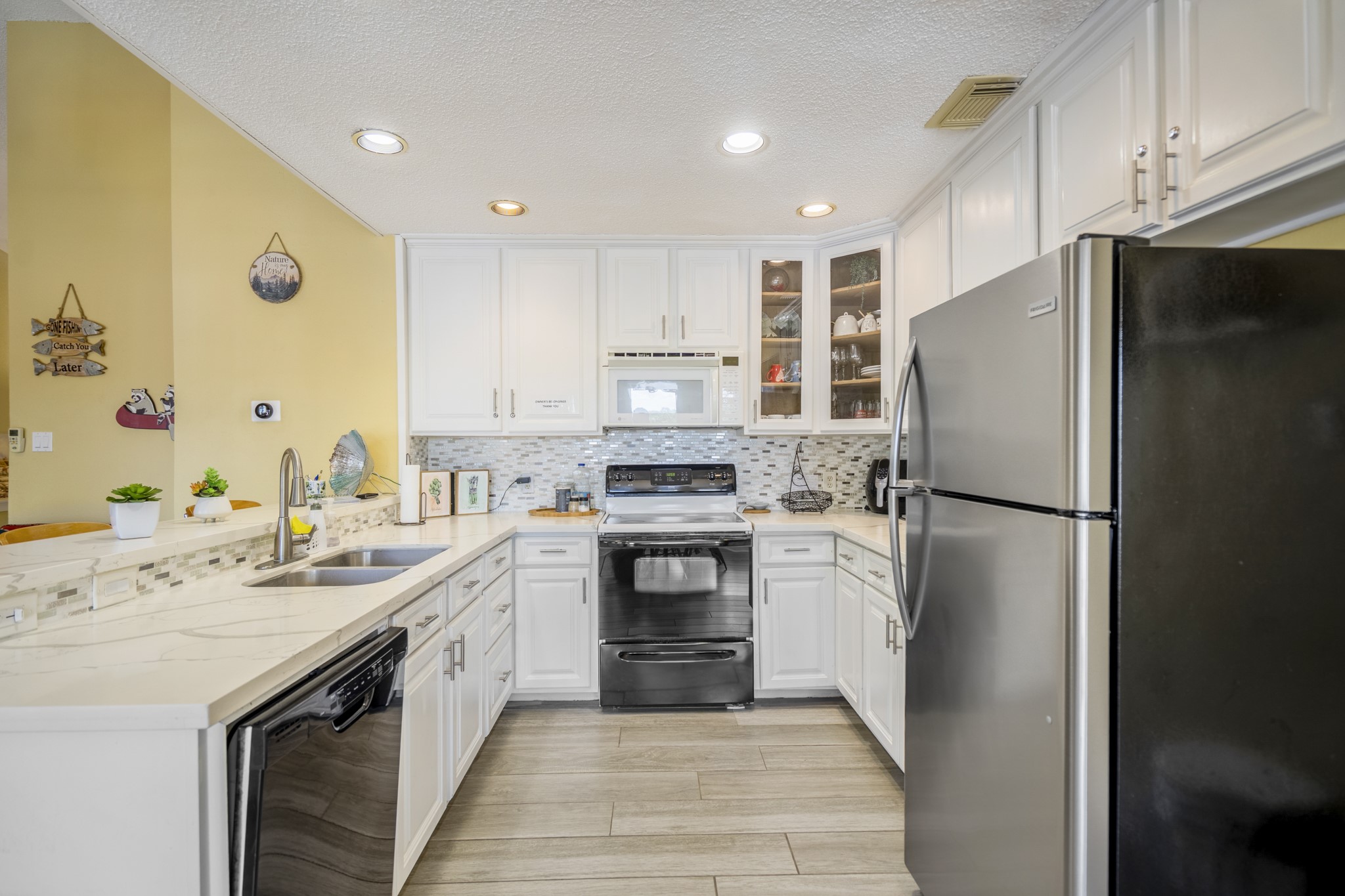 22547 Bayview Circle Point Blank, TX 77364 - Photo 14 of 46 a kitchen with a sink a refrigerator a oven and white cabinets