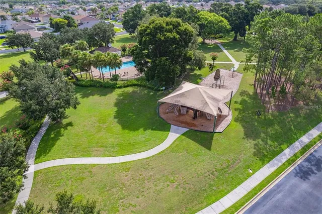 a view of an empty room with wooden floor and a ceiling fan